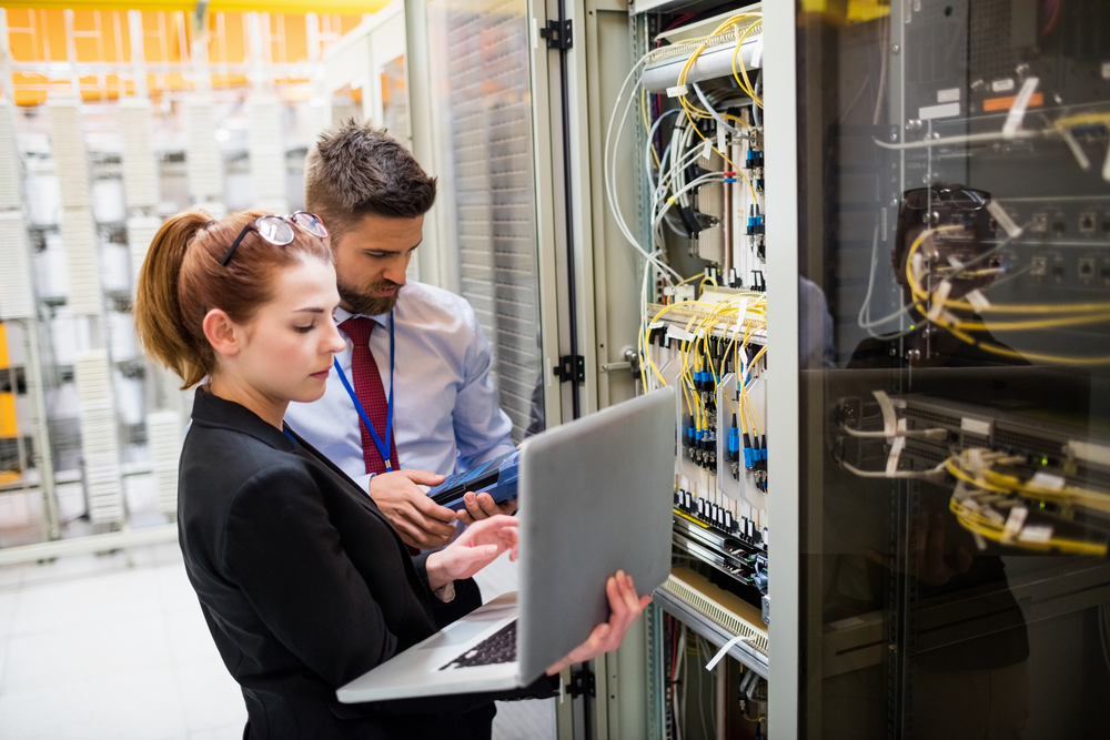 Photo of male and female technicians working on server rack
