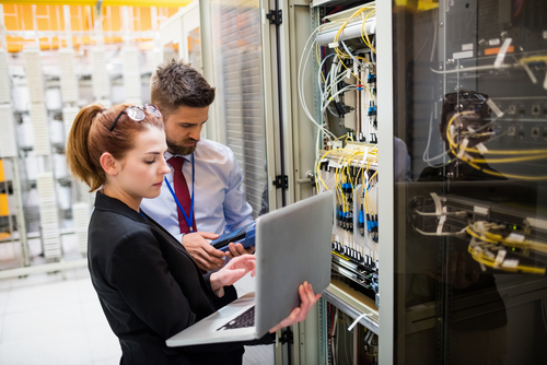 Male & Female Technicians working on a network server rack
